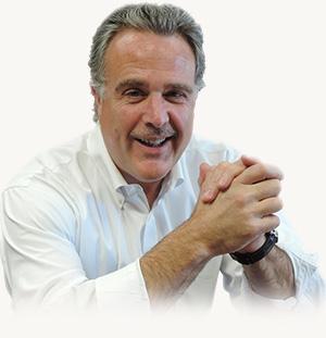 Robert S. Miller smiling with his hands clasped in front of him